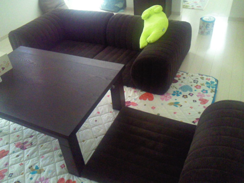 シックな色の家具に合わせたブラウンのローソファで落ち着けるリラックス空間が完成